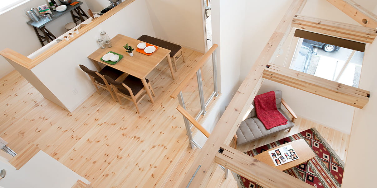 吹き抜け構造の明るいリビングダイニングを上から見下ろした室内写真