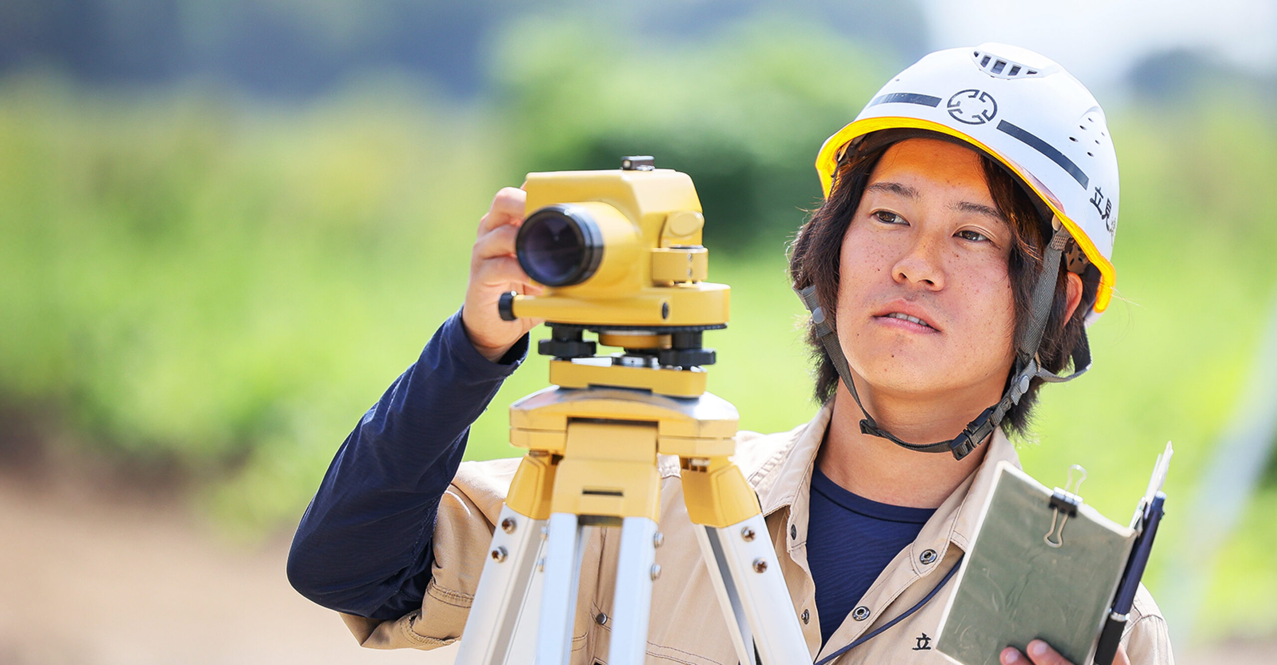 作業員がレベル測量機を操作している姿